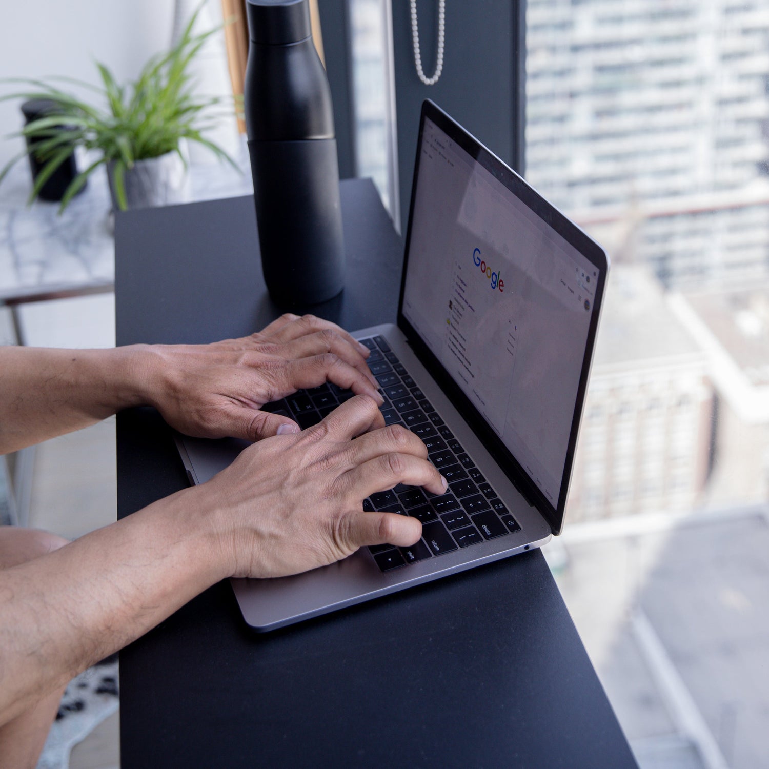 hands-type-on-a-laptop-with-google-home-screen